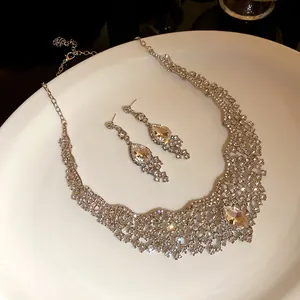 Detailed close-up of sparkling silver rhinestone necklace and teardrop earring set