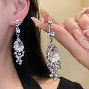 Close-up of elegant teardrop dangle earrings with many sparkling clear crystals