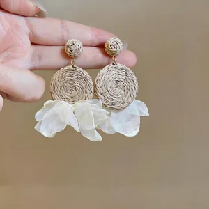Macro shot of Bohemian raffia drop earrings with delicate white chiffon floral petals