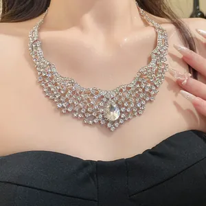 Luxurious hollow rhinestone necklace with a central pear-shaped crystal pendant on model.