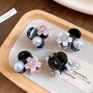 Dettaglio ravvicinato di mini fermagli per capelli con fiori di strass e perle lucide