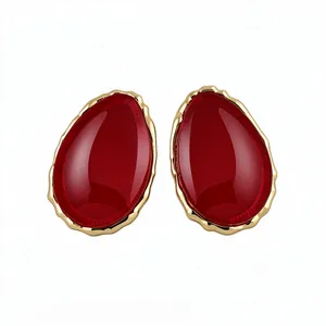Eleganti orecchini vintage a goccia in resina rossa con bordo in metallo dorato