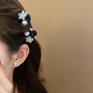 Primo piano di mini fermagli per capelli fiori perle eleganti su capelli castani e lisci