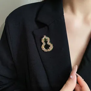 Κομψή επιχρυσωμένη καρφίτσα 18 καρατίων με ροζ και πράσινα ζιργκόν σε μαύρο σακάκι