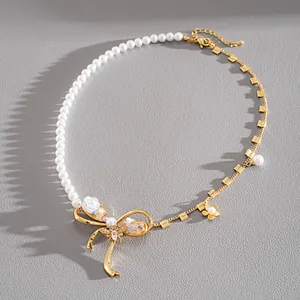 Detail of faux pearl necklace with gold bowknot, resin flower, and zircon bee charms