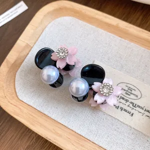 Dettaglio mini molletta per capelli a fiore con perle e strass luccicanti