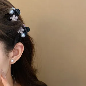 Dettagli macro di mini fermagli per capelli con perle e fiori di strass su capelli scuri