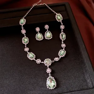 Luxury vintage jewelry set featuring green teardrop crystal necklace and matching stud earrings