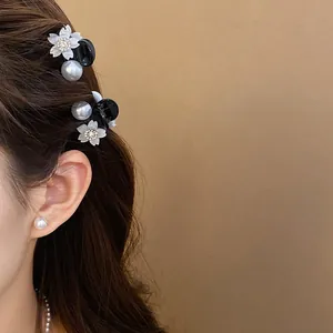 Dettaglio di una mini clip per capelli con fiori di strass e perle.