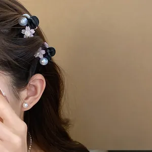 Elegante mini molletta per capelli con accenti floreali e perle indossata da una modella.