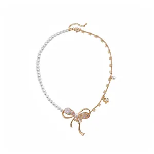 Asymmetrical pearl and gold bow necklace with resin flower and bee details