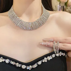 Dettaglio di girocollo a più file con strass scintillanti e orecchini a nappa su modella