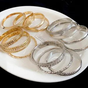Set of elegant minimalist hollow-out matte metal bracelets in gold and silver tones for women