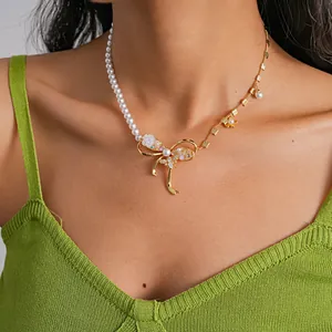 Close-up of a bow necklace with imitation pearls and bee detail on model's neck