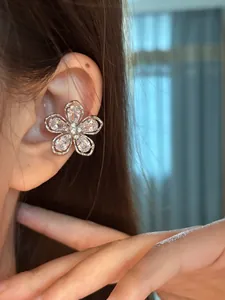 Vue détaillée d'un élégant clip d'oreille en forme de fleur en zircon sur une oreille