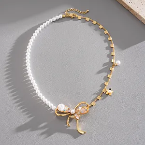 Detail view of an elegant pearl and gold chain necklace with a large jeweled bow.