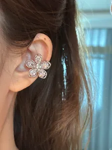 Détail du bijou d'oreille fleur en zircon porté sur l'oreille pour oreilles non percées