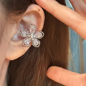 Vue macro détaillée d'un ear cuff floral en zircon étincelant porté sur l'oreille