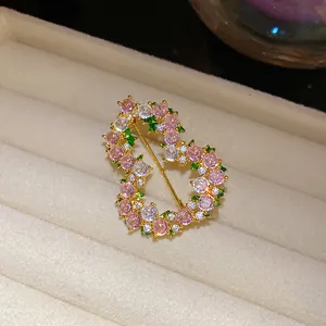Λεπτομέρεια πολυτελούς καρφίτσας 18k με πολύχρωμα ζιργκόν σε κομψό σχέδιο καρδιάς