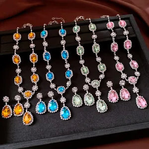 Macro shot of colorful rhinestone necklace and teardrop earring sets in various colors.