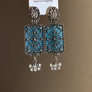 Dettaglio di orecchini a pendente quadrati stile vintage con strass e intarsio blu