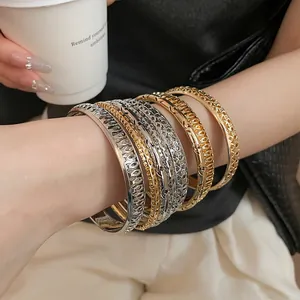 Close-up of matte hollow-out irregular metal bangles on a wrist