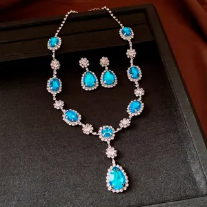 Elegant silver necklace and earrings set featuring light blue teardrop rhinestones