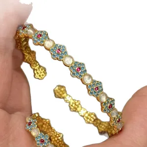 Vintage palace style gold-plated bangle with blue enamel flowers and cat's eye stones