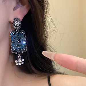 Primo piano di orecchini pendenti quadrati stile vintage con strass e smalto blu