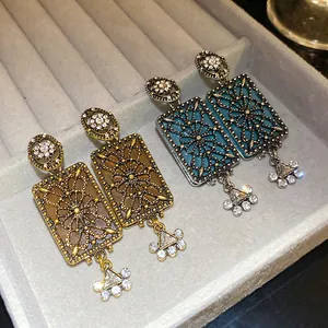 Dettaglio di orecchini pendenti quadrati in stile palazzo vintage con strass lucidi