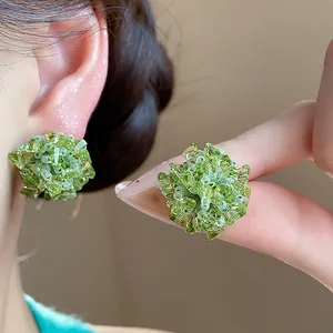 Primer plano de pendientes de flores de cristal verde con detalles de cristal.
