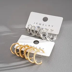 Macro detail of 6-piece gold and silver geometric hoop earring set on display cards