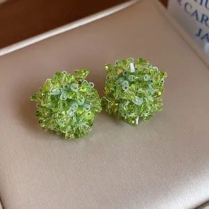 Detalle macro de los pendientes de botón de flores con cuentas de vidrio verde bosque