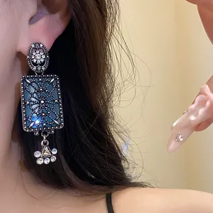 Dettaglio di un orecchino vintage in argento con ciondolo rettangolare blu e strass