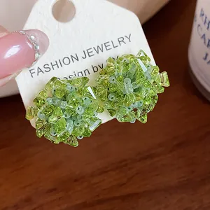 Primer plano de pendientes de flores de cristal verde con un elegante diseño de estilo forestal