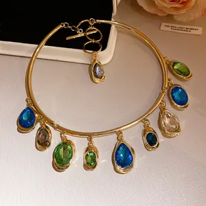 Détail avec des pendentifs en cristal ovales et en goutte sur un choker doré