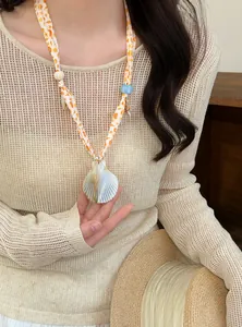 Detail view of a shell starfish printed scarf necklace with a large natural shell pendant.