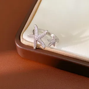 Close-up of a silver-toned open ring with pavé-set zirconia starfish details