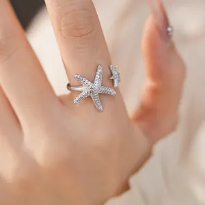 Macro view of pavé-set zircon starfish motifs on an elegant silver-tone open ring