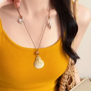 Bohemian beach style necklace featuring leather cord and natural seashell pendants
