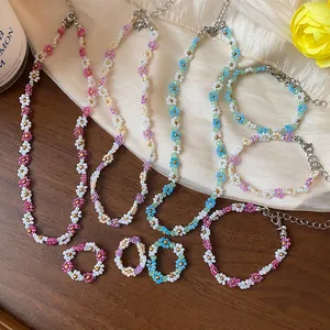 Vue détaillée d'un ensemble de colliers, bracelets et bagues en perles de verre fleurs