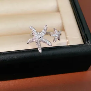 Detailed view of silver starfish open ring with sparkling cubic zirconia stones.