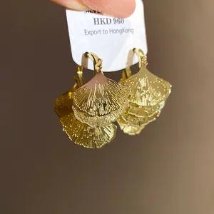 Nahaufnahme der feinen Texturen dieser goldfarbenen Ginkgo-Blatt-Fächerohrringe.
