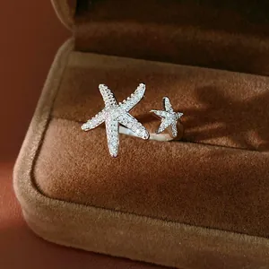 Close-up of a sparkling silver starfish open ring with zircon stones in a velvet box