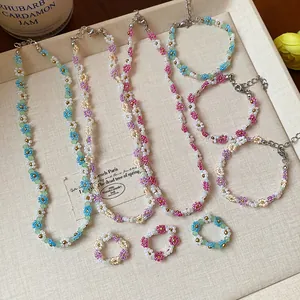 Détail de la parure de bijoux faite main avec colliers et bracelets fleurs perlées
