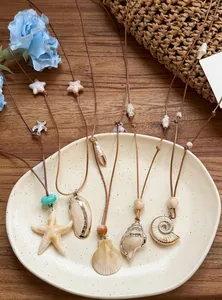 Detail of ocean-themed necklaces featuring starfish and shell pendants on leather cords.