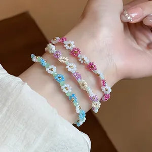 Gros plan de bracelets de fleurs en perles faits main colorés sur un poignet, style tendance.