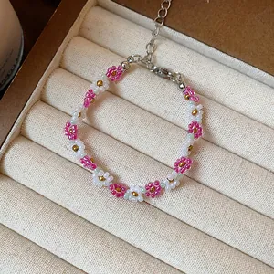 Gros plan sur un bracelet à fleurs en perles de verre roses et blanches fait main