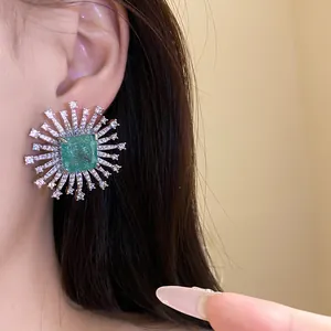 Detailed shot of radiant starburst stud earring with a square green center stone