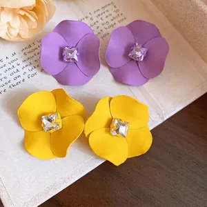 Pendientes de flores mate elegantes con cristales cuadrados en púrpura y amarillo.
